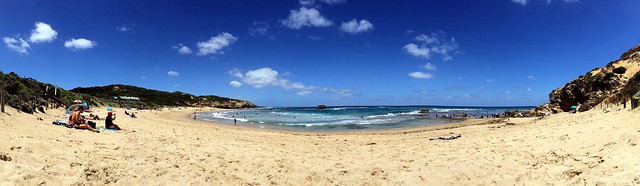 Beach photo with people sitting on the sand